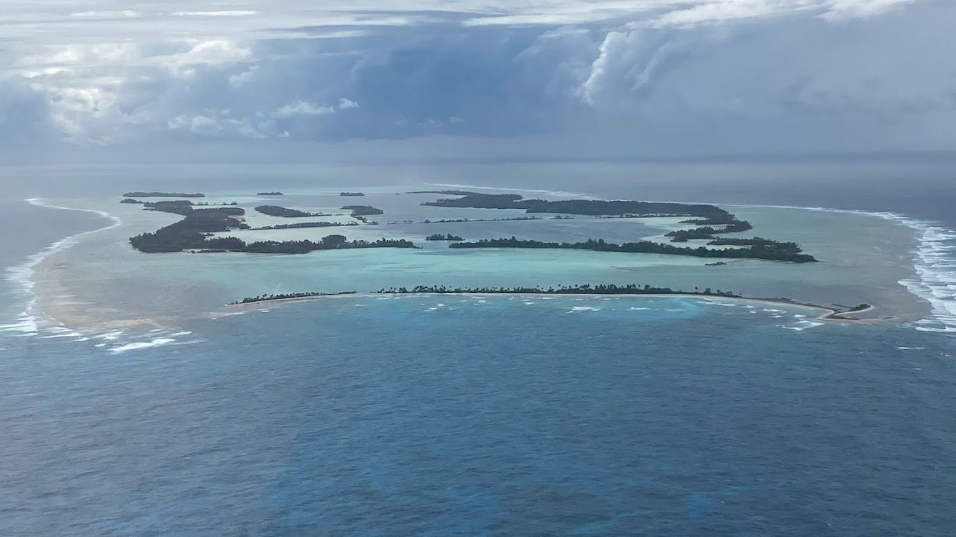 Aerial view of the forested coral atoll of Palmyra, surrounded by ocean.